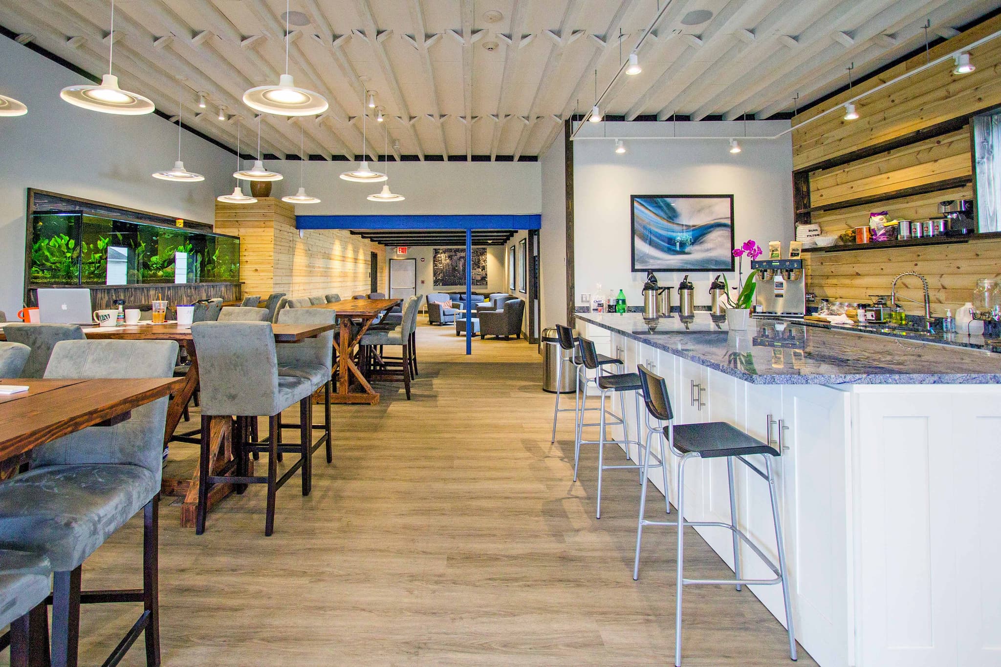 Modern cafe and amenities area with bar seating and beverage station